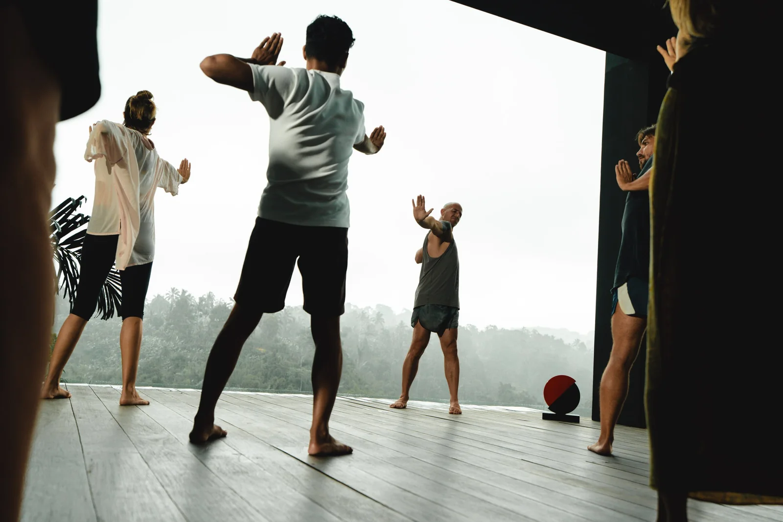 Group movement practice on the villa deck in the rain, Bali
